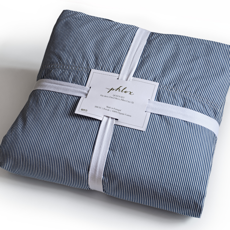 Folded blue and white striped fabric set with a label on a white background. 100% Organic percale cotton bed sheets. 