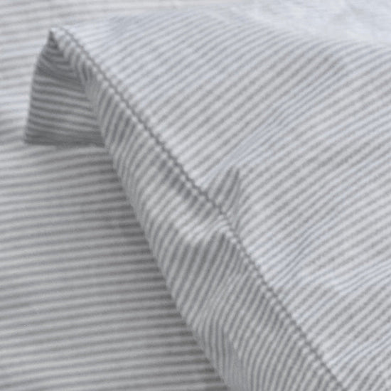 Close-up of gray striped fabric with a subtle pattern.100% Organic percale cotton.