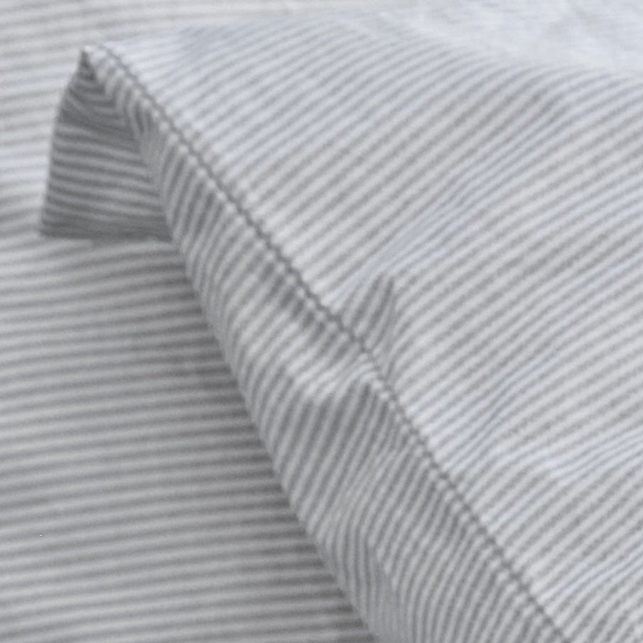 Close-up of gray striped fabric with a subtle pattern.100% Organic percale cotton.
