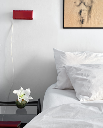 Bedroom with white striped bedding, a red lamp, and a framed picture on the wall. 100% Organic percale cotton.