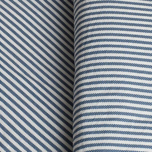 Close-up of fabric with blue and white striped pattern. 100% Organic percale cotton bed sheets. 
