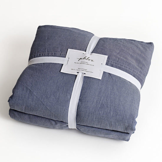 Folded denim fabric with a label on a white background