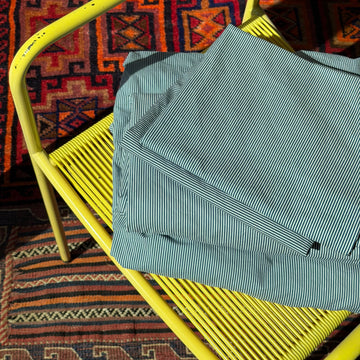 Blue striped fabric on a yellow chair with a patterned rug underneath. 100% Organic Cotton Bed Sheets